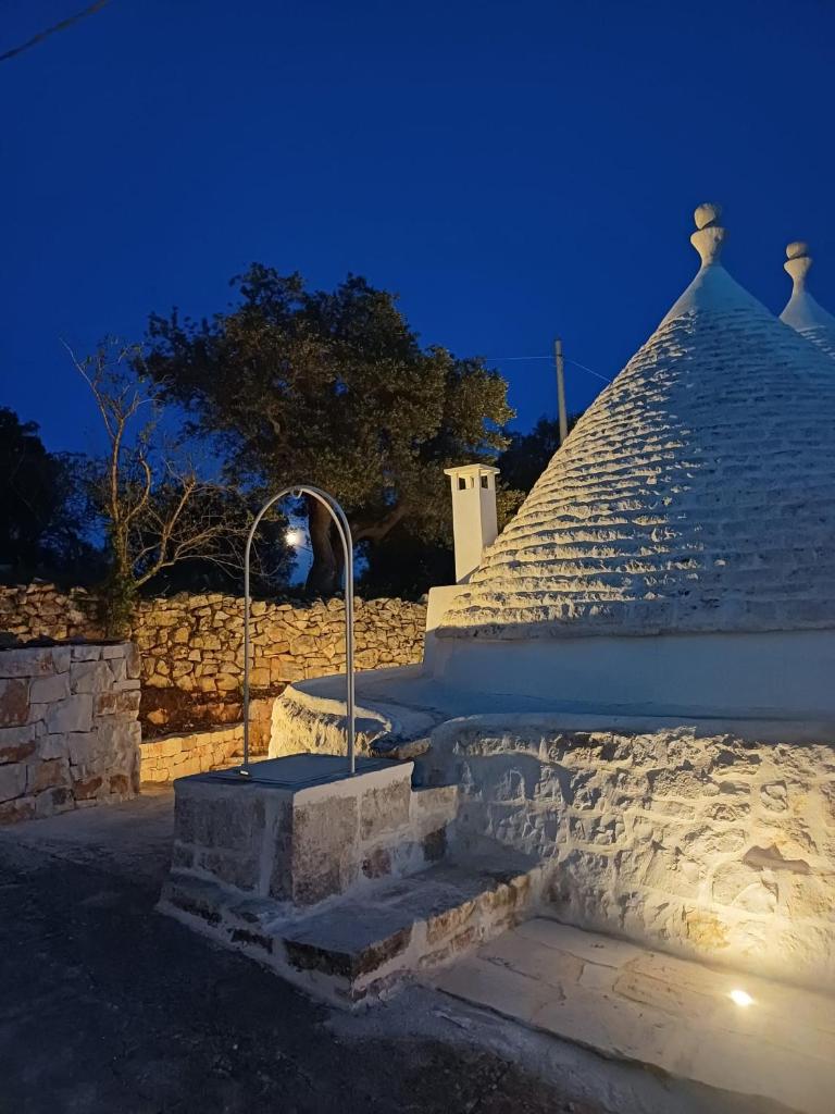 un bâtiment en pierre avec un escalier la nuit dans l'établissement Trullo Terra Bianca, à Ostuni