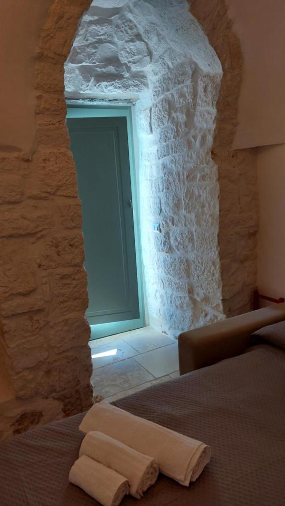 - une chambre avec une fenêtre dans un mur en pierre dans l'établissement Trullo Terra Bianca, à Ostuni