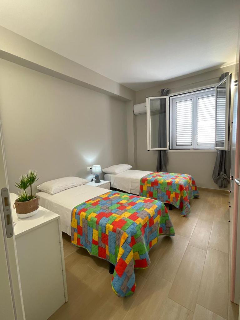 une chambre d'hôtel avec deux lits et une télévision dans l'établissement Villa San Giorgio Sciacca, à Sciacca