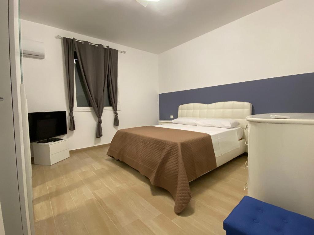 une chambre avec un lit et une télévision à écran plat dans l'établissement Villa San Giorgio Sciacca, à Sciacca
