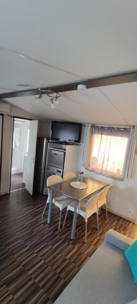 une cuisine et une salle à manger avec une table et des chaises dans l'établissement Mobil home Camping Les Embruns 4 étoiles, à Lège-Cap-Ferret