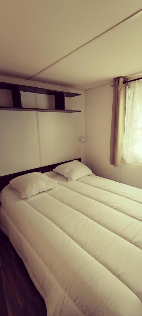 - 2 lits blancs dans une chambre avec fenêtre dans l'établissement Mobil home Camping Les Embruns 4 étoiles, à Lège-Cap-Ferret 7 autres photos