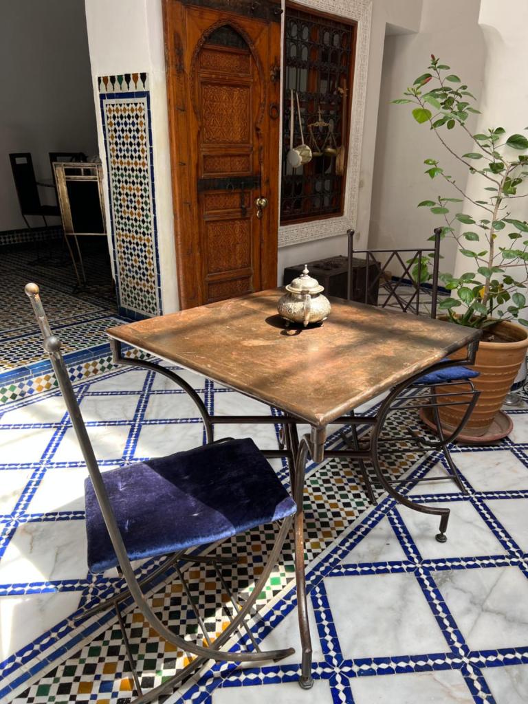 - une table en bois et une chaise dans la chambre dans l'établissement Dar Faracha Fes, à Fès