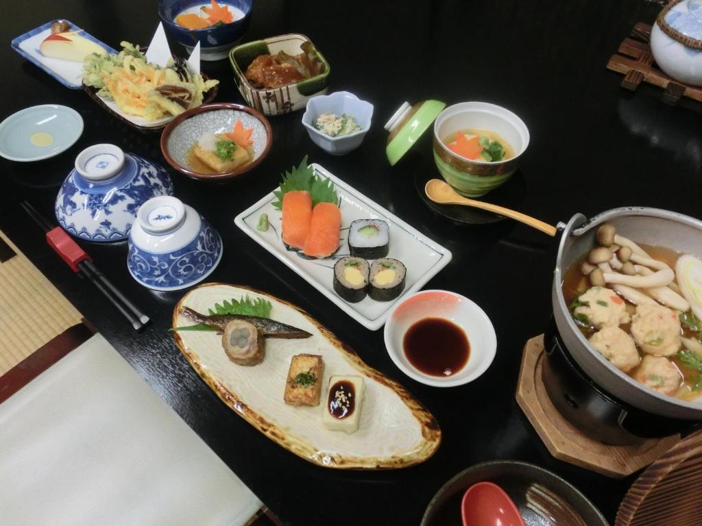une table recouverte de plateaux de sushis et d'autres aliments dans l'établissement Tajimaya, à Nakatsugawa