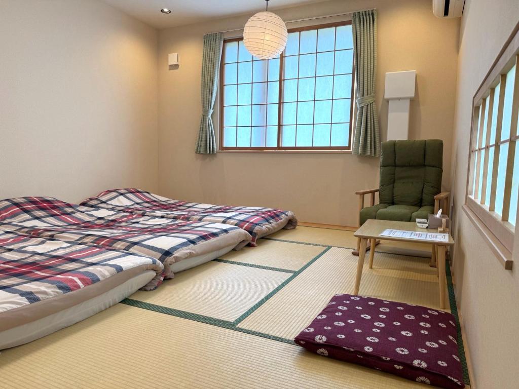 une chambre avec un lit, une chaise et un tapis dans l'établissement Plum House Otaru, à Otaru 37 autres photos