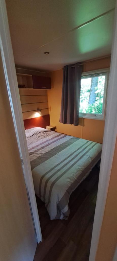 une chambre avec un lit et une fenêtre dans l'établissement Camping Les Galets, à Banassac