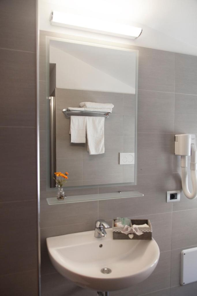 une salle de bain avec un lavabo blanc et un miroir dans l'établissement Hotel Gabbiano, à Rimini 132 autres photos