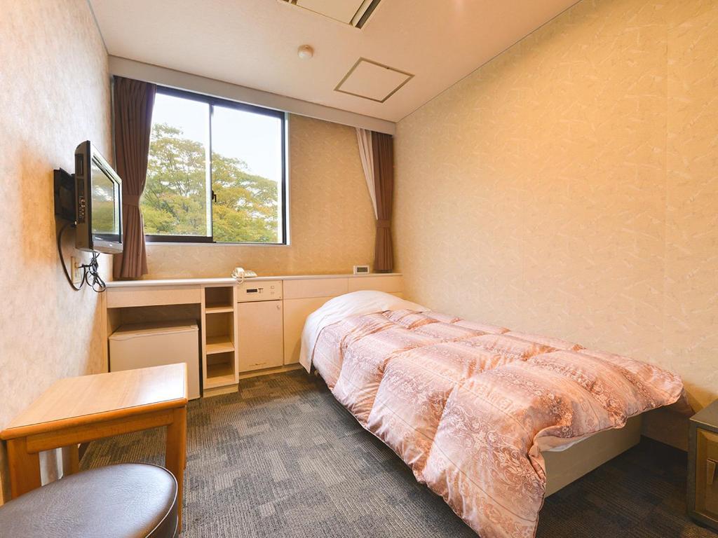 une chambre avec un lit, un bureau et une fenêtre dans l'établissement Ooedo Onsen Monogatari Premium Hotel New Shiobara, à Nasushiobara
