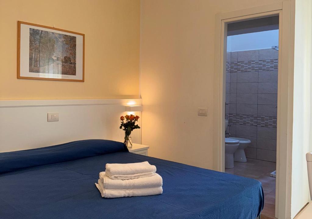 une chambre avec un lit bleu avec des serviettes dessus dans l'établissement Hotel Riviera Nuova Gestione, à Cattolica
