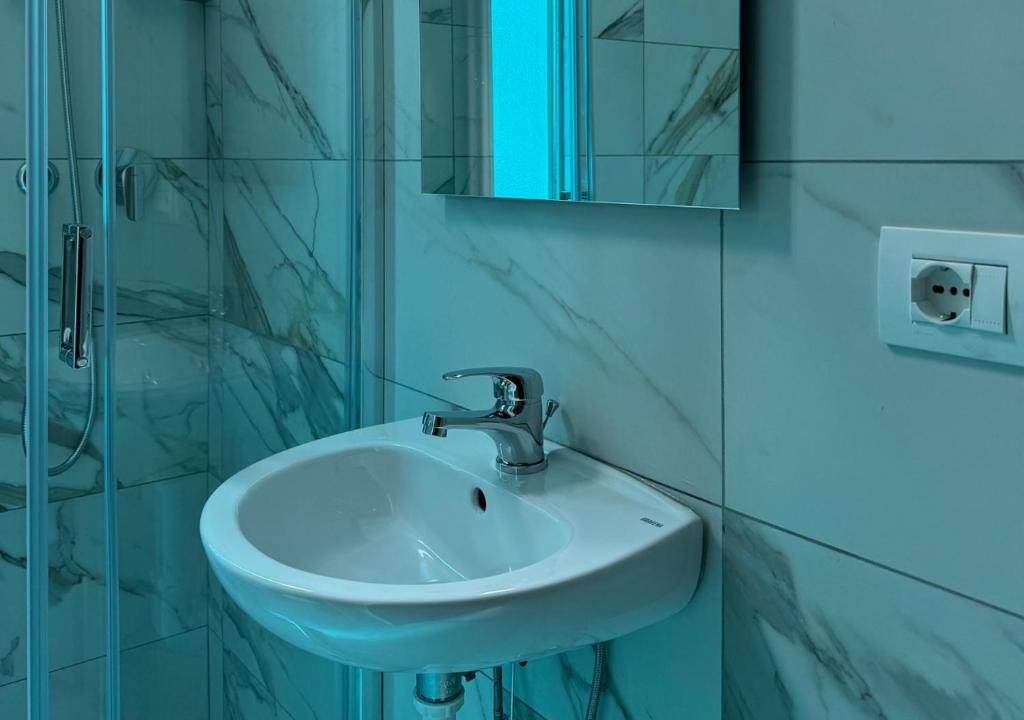 une salle de bain avec un lavabo blanc et un miroir dans l'établissement Hotel Riviera Nuova Gestione, à Cattolica