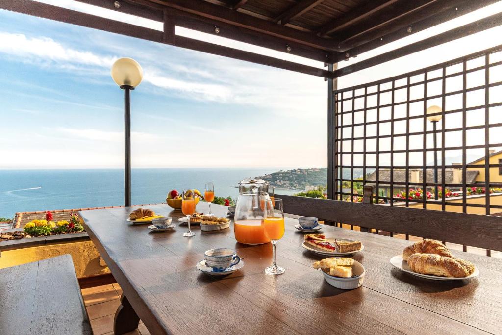 - une table avec de la nourriture et des boissons sur le balcon dans l'établissement "Villa dei Poeti" private pool and breathtaking sea view, à Arenzano