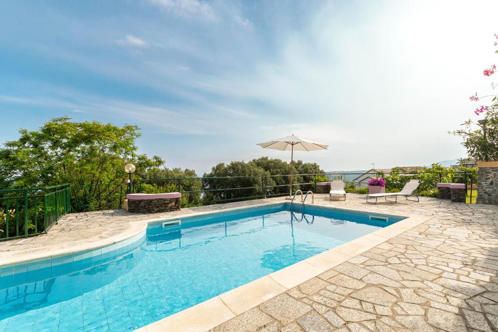 - une piscine avec une terrasse et un parasol dans l'établissement "Villa dei Poeti" private pool and breathtaking sea view, à Arenzano