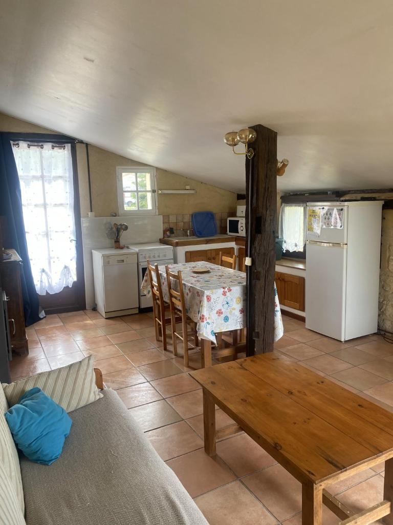 un salon avec une table et une cuisine dans l'établissement Ensemble 7 gîtes avec Piscines 50 couchages, Les Naudines Cottages, à Gageac-et-Rouillac