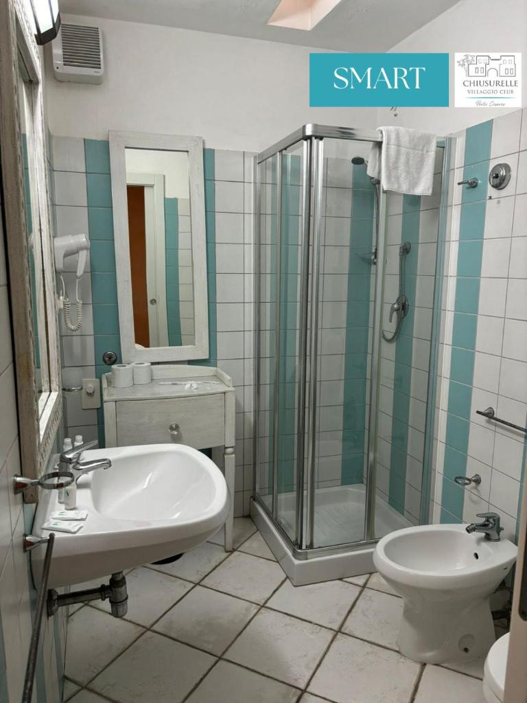 une salle de bain avec un lavabo, une douche et des toilettes dans l'établissement Chiusurelle Village Resort, à Punta Prosciutto 42 autres photos