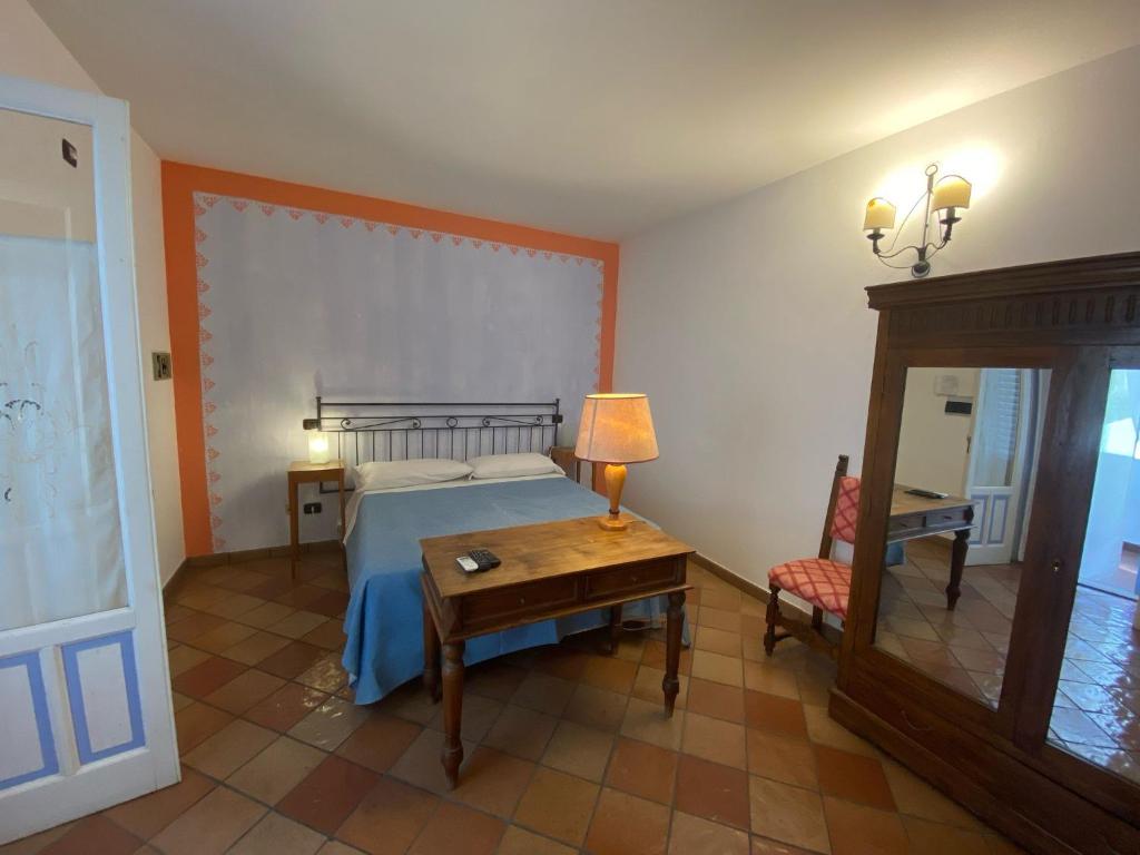 une chambre avec un lit et une table avec une lampe dans l'établissement Albergo Boutique Casajanca, à Canneto