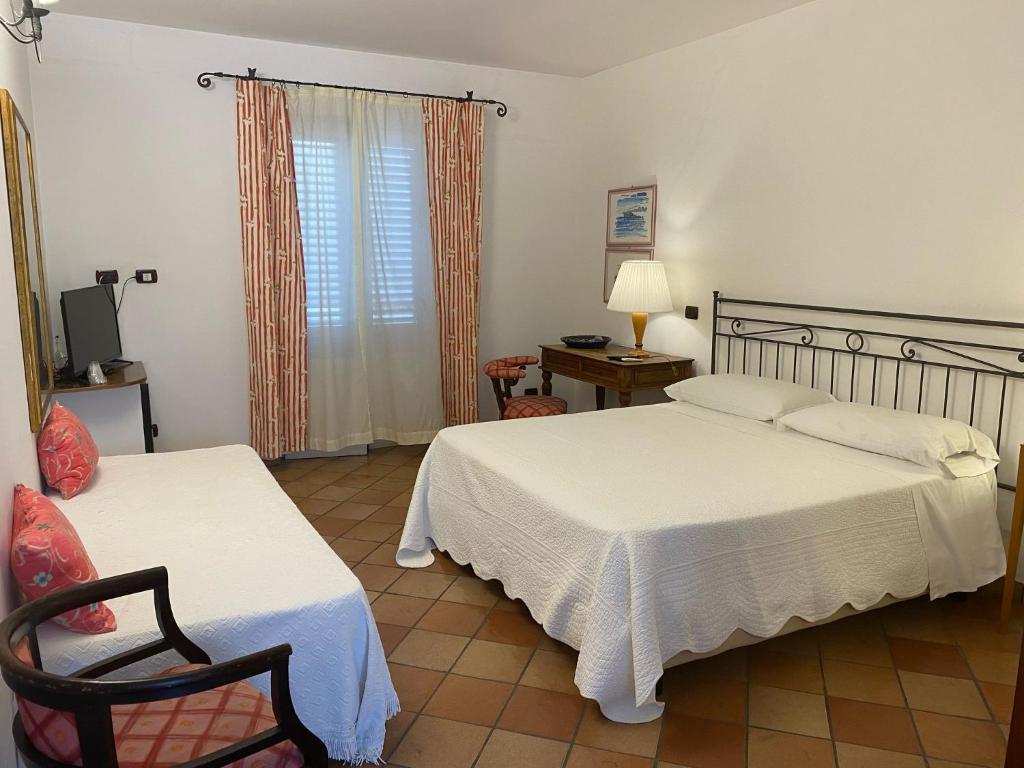 une chambre avec deux lits et une chaise et une fenêtre dans l'établissement Albergo Boutique Casajanca, à Canneto