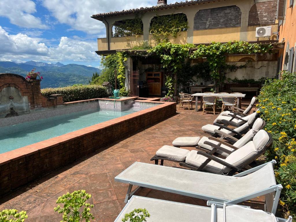 un groupe de chaises longues assises à côté d'une piscine dans l'établissement Beautiful Serena, à Coreglia Antelminelli