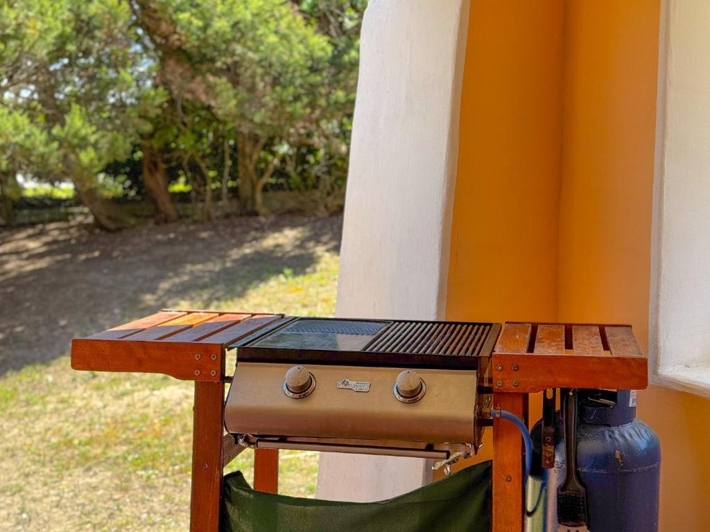 - un barbecue installé à côté d'une maison dans l'établissement Villa Rosy - Comfort e Piscina Privata by Host Hero, à Stintino 76 autres photos