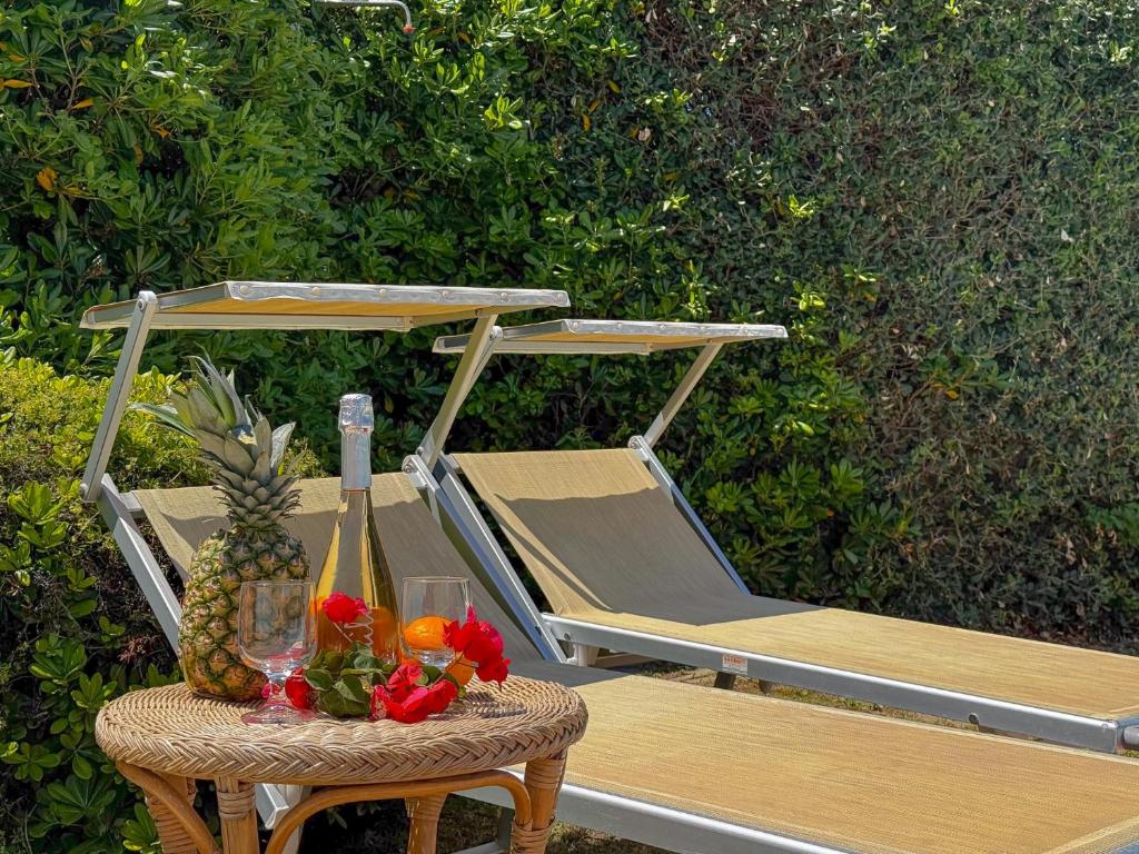 une table avec une chaise et une table avec un ananas dans l'établissement Villa Rosy - Comfort e Piscina Privata by Host Hero, à Stintino