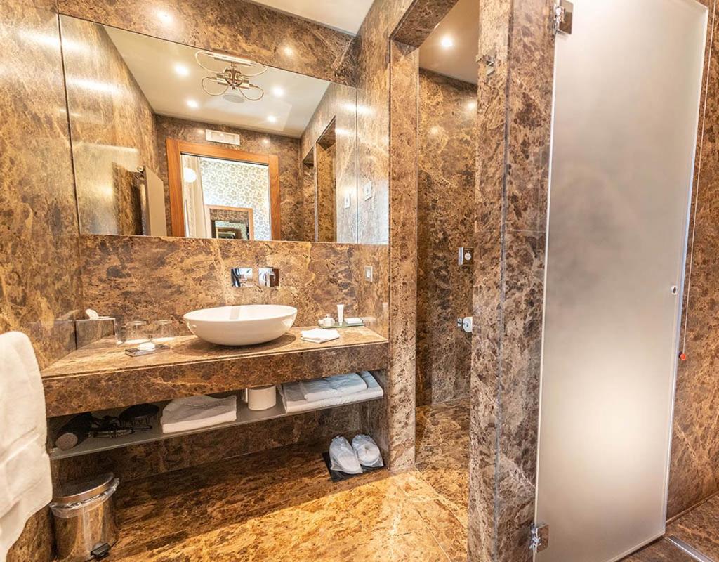 une salle de bain avec un lavabo et un miroir dans l'établissement Villa Lario Resort Mandello, à Mandello del Lario 56 autres photos