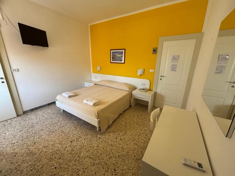 - une chambre avec un lit et un mur jaune dans l'établissement Delfino, à Marina di Camerota 51 autres photos