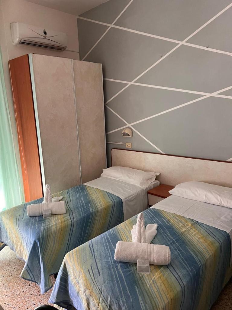 deux lits dans une pièce avec des animaux en peluche dessus dans l'établissement Hotel moroni, à Rimini