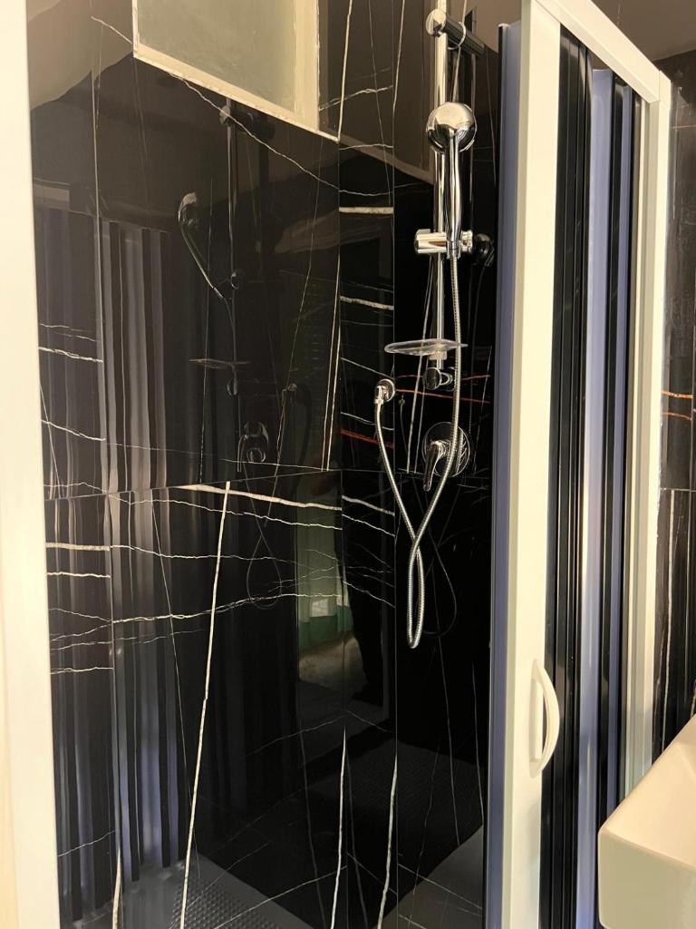 une douche avec pommeau de douche dans une salle de bain dans l'établissement Hotel moroni, à Rimini