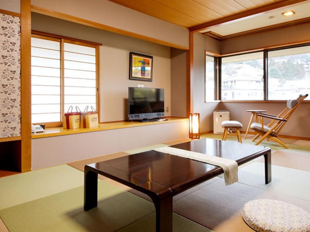 - un salon avec une table basse et une télévision dans l'établissement Arima Hot Spring Ryokan Kotori, à Kobe