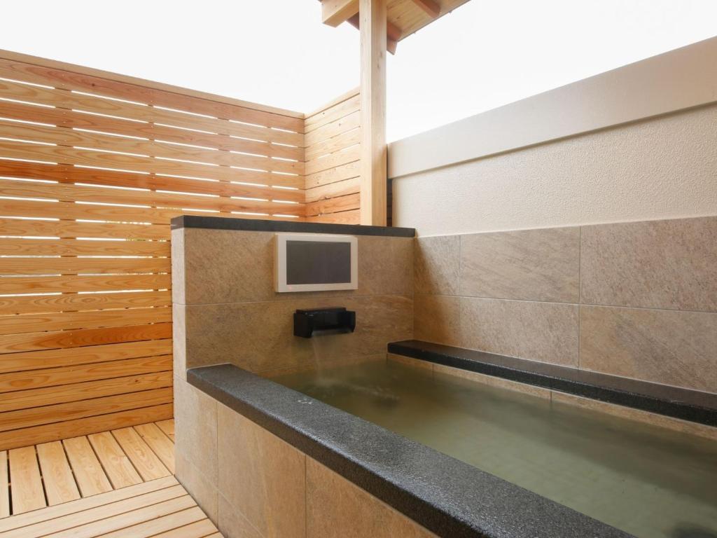 - une piscine dans une chambre dotée d'une télévision murale dans l'établissement Arima Hot Spring Ryokan Kotori, à Kobe