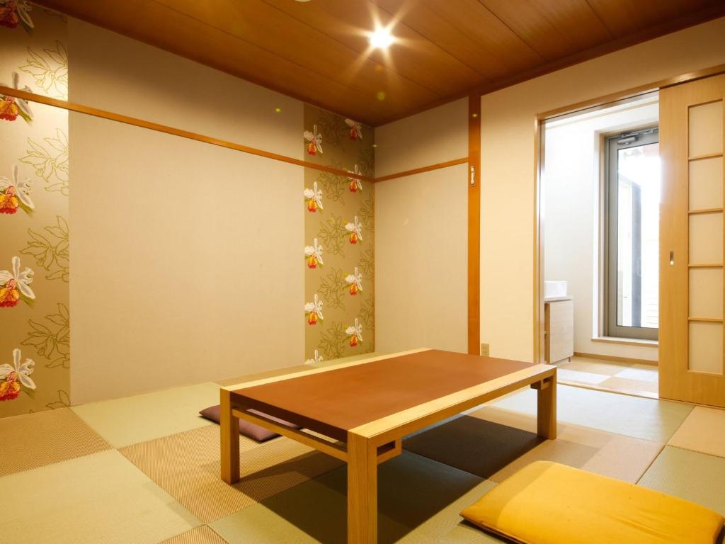 Cette chambre dispose d'une table en bois et d'une fenêtre. dans l'établissement Arima Hot Spring Ryokan Kotori, à Kobe