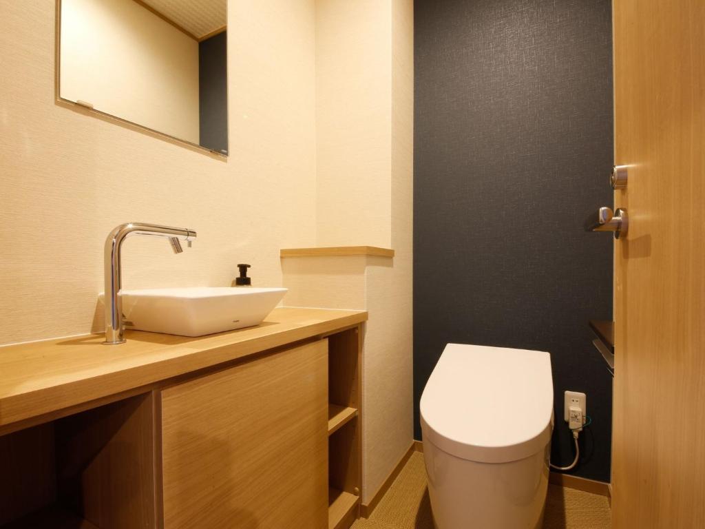une salle de bain avec des toilettes blanches et un lavabo dans l'établissement Arima Hot Spring Ryokan Kotori, à Kobe