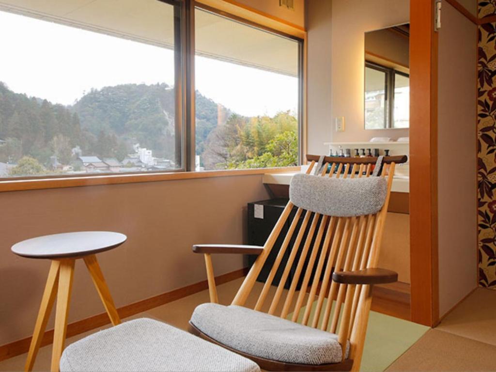 une chambre avec trois chaises, une table et une fenêtre dans l'établissement Arima Hot Spring Ryokan Kotori, à Kobe 37 autres photos