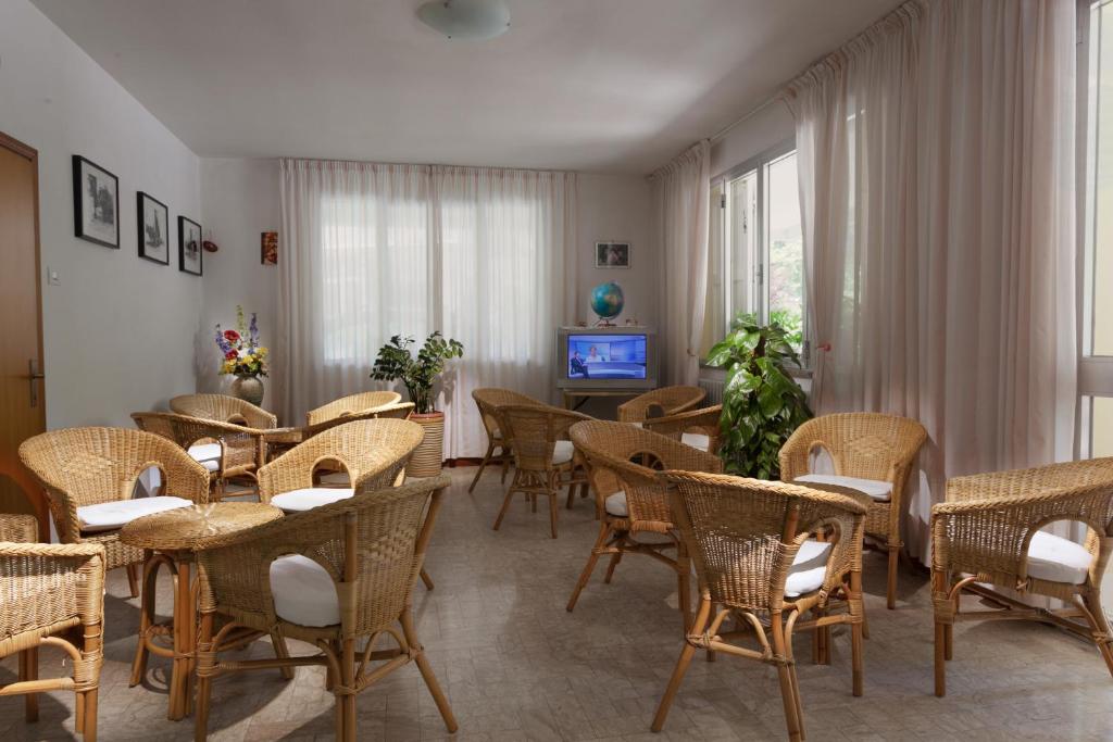 une salle à manger avec tables et chaises et une télévision dans l'établissement Hotel Gattuccio, à Cesenatico