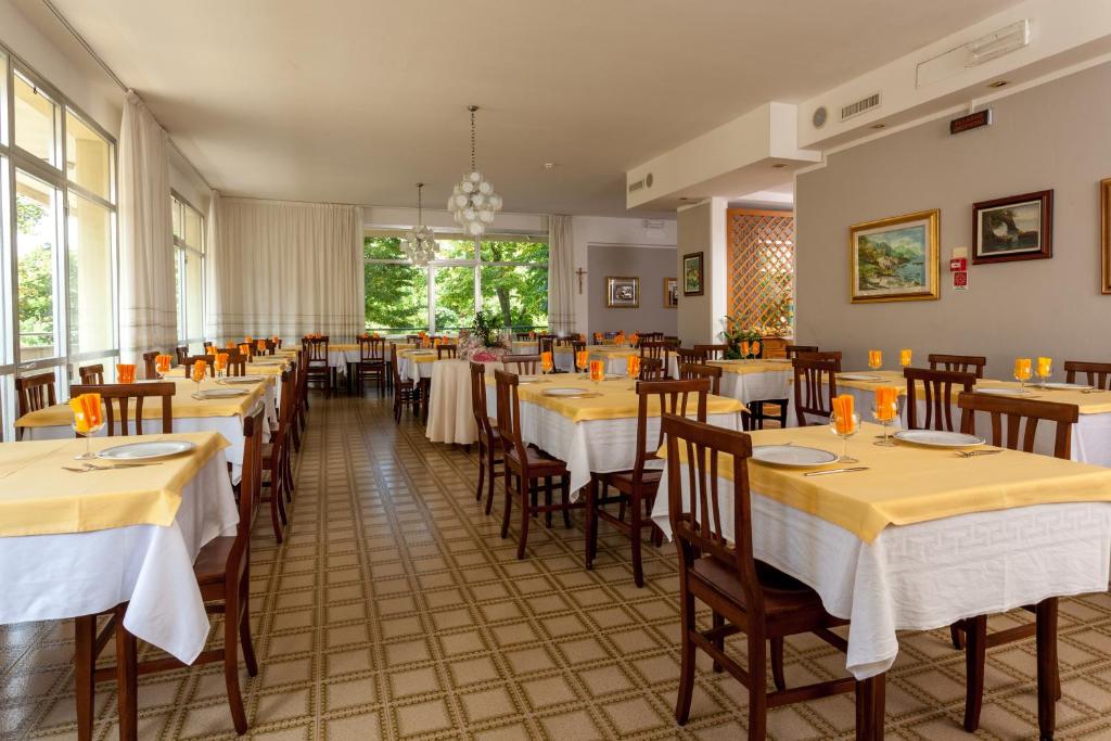 un restaurant avec des tables et des chaises dans une salle dans l'établissement Hotel Gattuccio, à Cesenatico