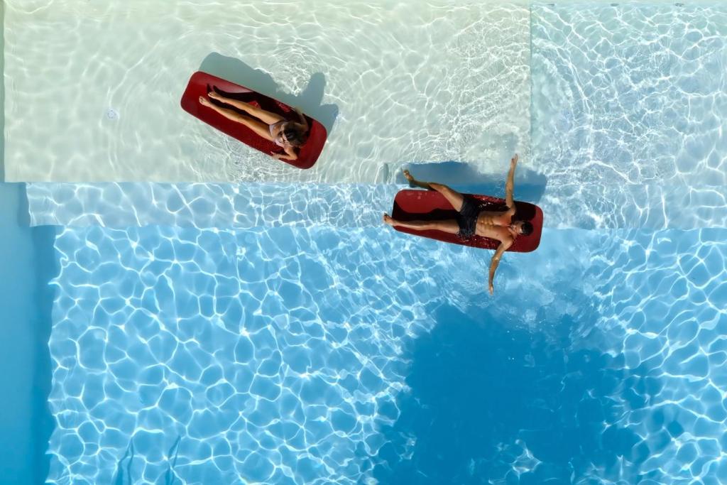 2 personnes nagent dans une piscine dans l'établissement Hotel Cristallo, à Senigallia