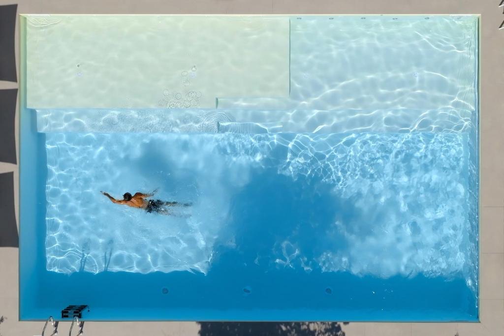 une personne faisant un tour dans une piscine dans l'établissement Hotel Cristallo, à Senigallia