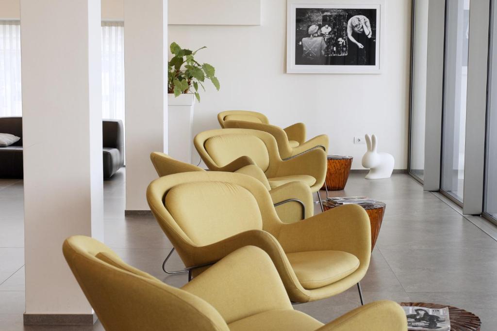 une rangée de chaises jaunes dans une pièce dans l'établissement Hotel Cristallo, à Senigallia