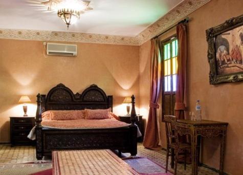 une chambre avec un lit, une table et une fenêtre dans l'établissement Le Riad Meknes, à Meknès 20 autres photos