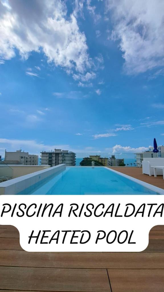 une vue d'une piscine chauffée sur le toit d'un hôtel dans l'établissement Hotel Villa Eugenia - 3 Stelle Superior con Private SPA e Piscina, à Lido di Jesolo