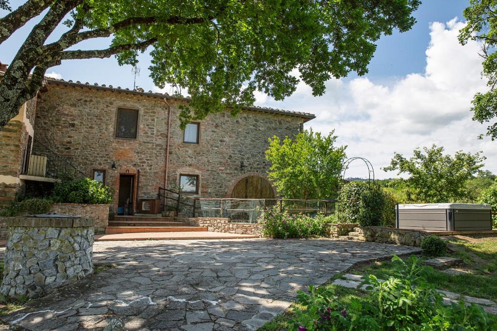 - une vue extérieure sur une maison avec une allée en pierre dans l'établissement Villa Bella Lisa with Pool and Jacuzzi, à Cavriglia