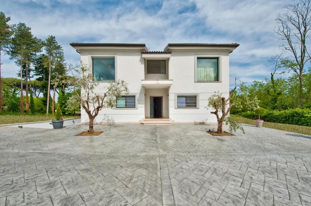 une maison blanche avec deux arbres devant elle dans l'établissement Villa dei Gelsomini, à Rocca di Papa 34 autres photos