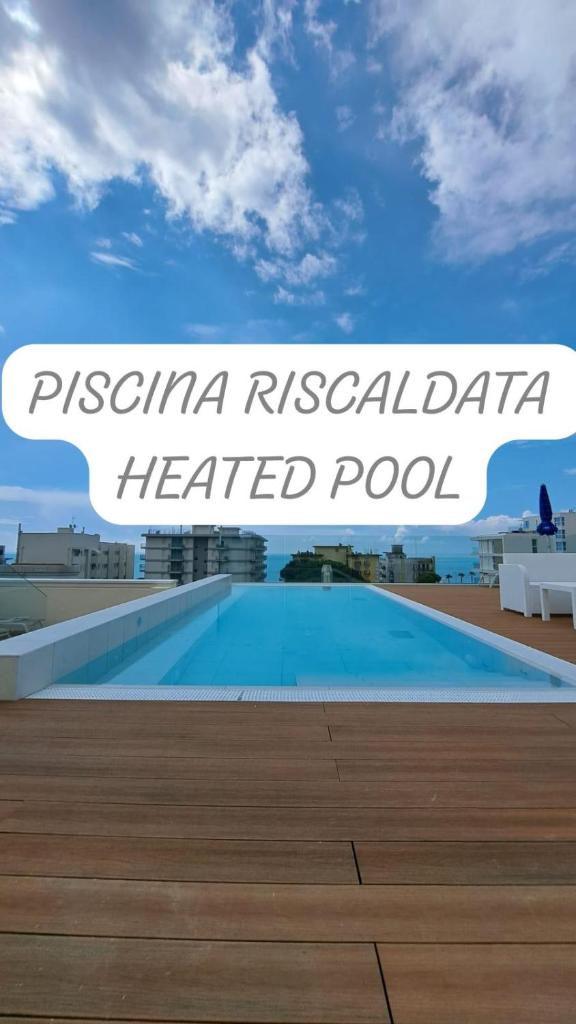 un panneau indiquant une piscine chauffée dans un complexe hôtelier dans l'établissement Hotel Villa Eugenia - 3 Stelle Superior con Private SPA e Piscina, à Lido di Jesolo