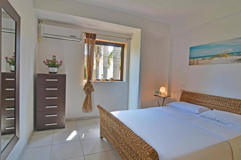 une chambre avec un grand lit et une fenêtre dans l'établissement Villa Garofani by Villa Plus, à Punta Secca