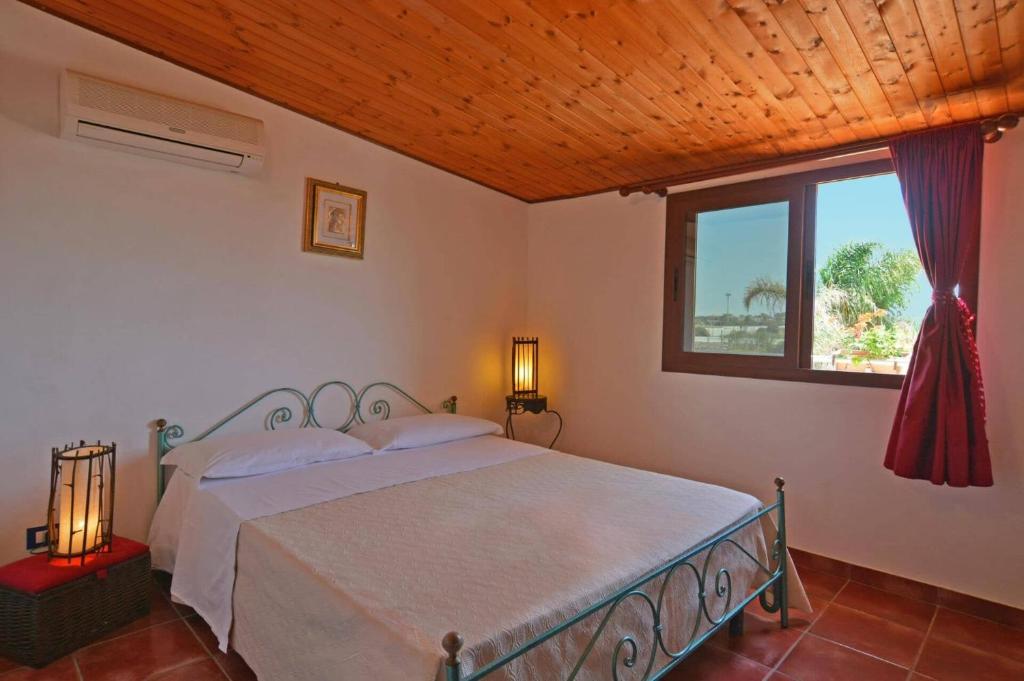 une chambre avec un lit et une fenêtre dans l'établissement Villa Garofani by Villa Plus, à Punta Secca 39 autres photos