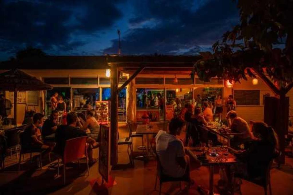 un groupe de personnes assises dans un restaurant la nuit dans l'établissement Camping 3 étoiles - Piscine - ccaaffc, à Prigny 37 autres photos