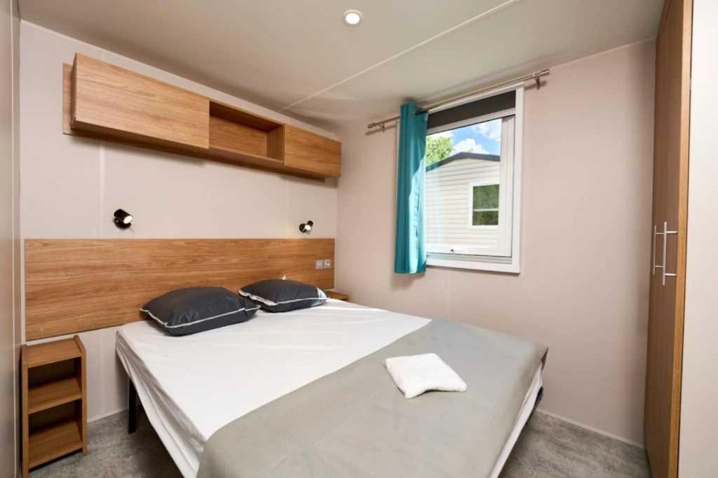 une chambre avec un grand lit blanc avec une fenêtre dans l'établissement Camping 3 étoiles - Piscine - efaeh0, à Malemort-du-Comtat