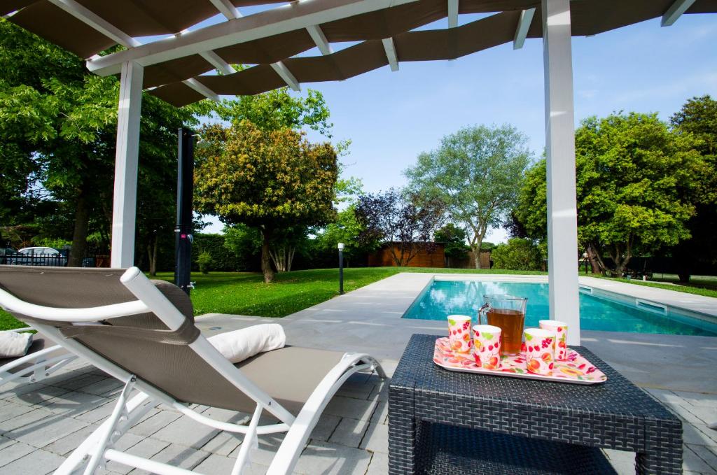 une table et une chaise sur une terrasse à côté d'une piscine dans l'établissement Villa Asia, private villa with pool, à Panicarola