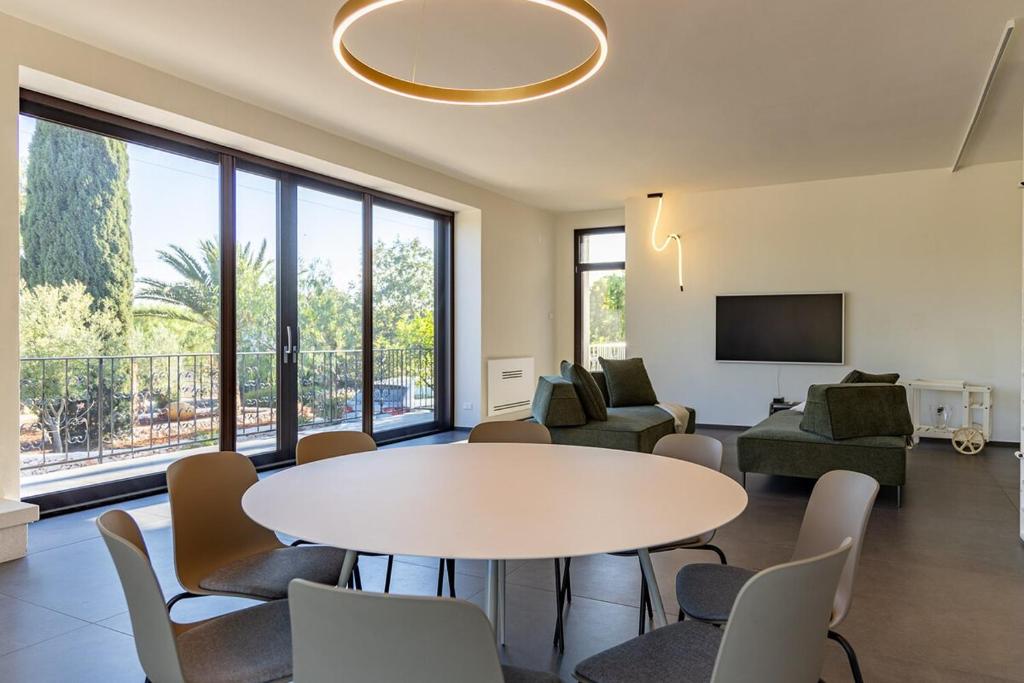 un salon avec une table et des chaises dans l'établissement Ostuni Escape Villa Galeone &infinity Pool 16x4m, à Ostuni