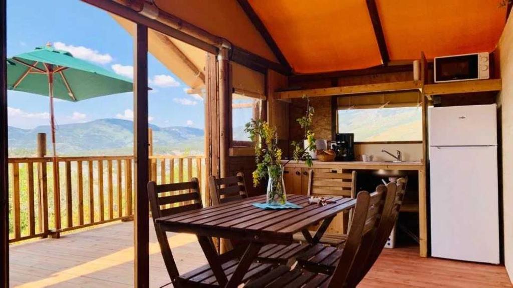 Il comprend un balcon et une cuisine équipée d'une table et d'un réfrigérateur. dans l'établissement Camping 4 étoiles - Piscine - ccbacgb, à Rosans