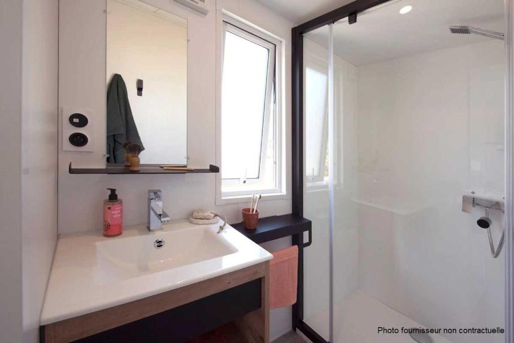 une salle de bain avec un lavabo blanc et une douche dans l'établissement Camping 3 étoiles - Piscine - ccbaddh, à Louvie Juzon